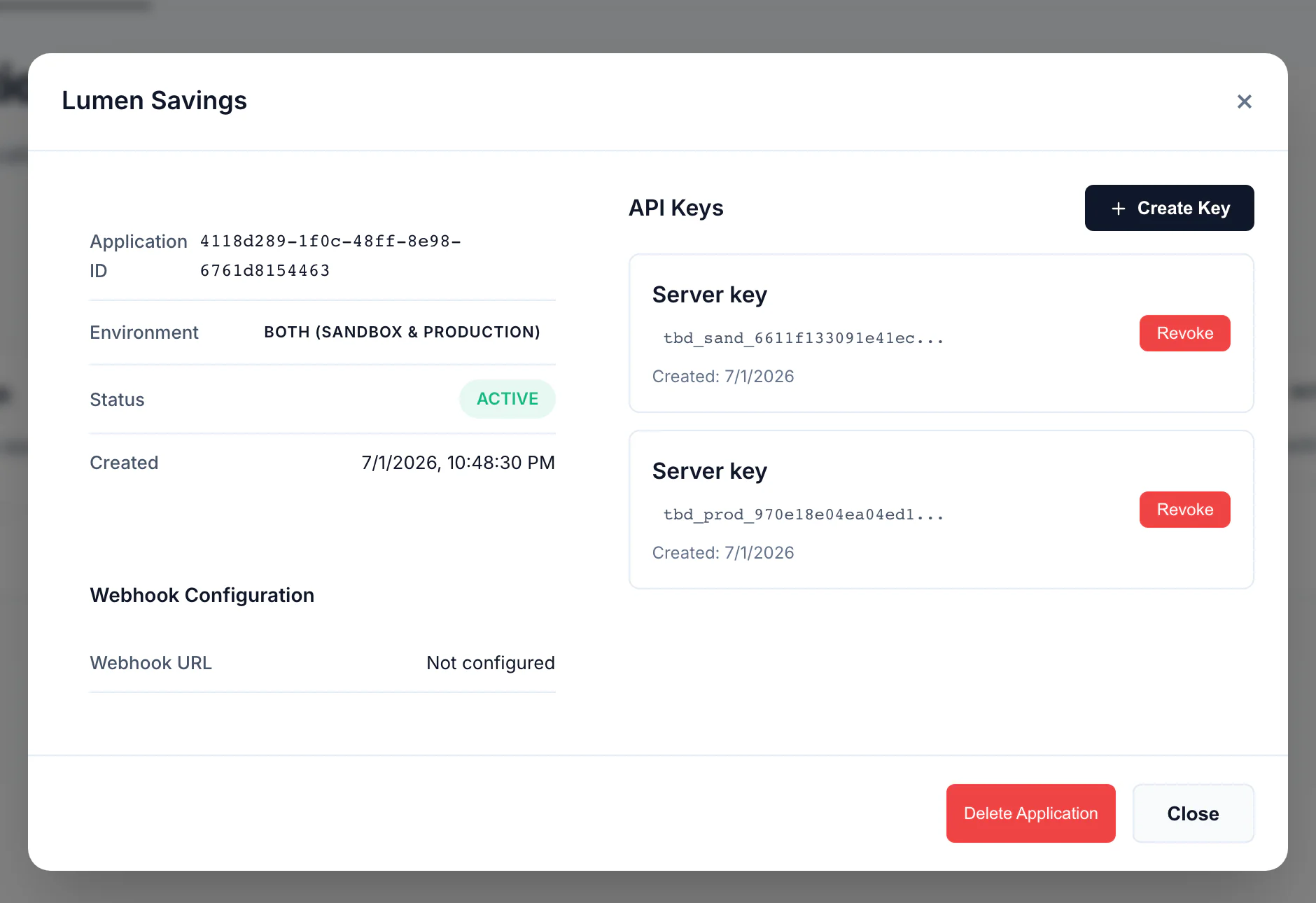 Application detail modal for Lumen Savings: application ID, environment badge, status, webhook configuration, and an API Keys panel holding one tbd_sand_ and one tbd_prod_ key with revoke buttons