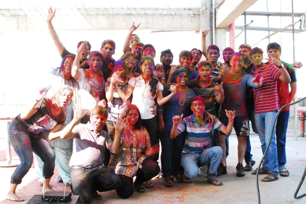 Mike Ward with about thirty members of Coyote's Pune, India development team, covered in Holi colors on a rooftop